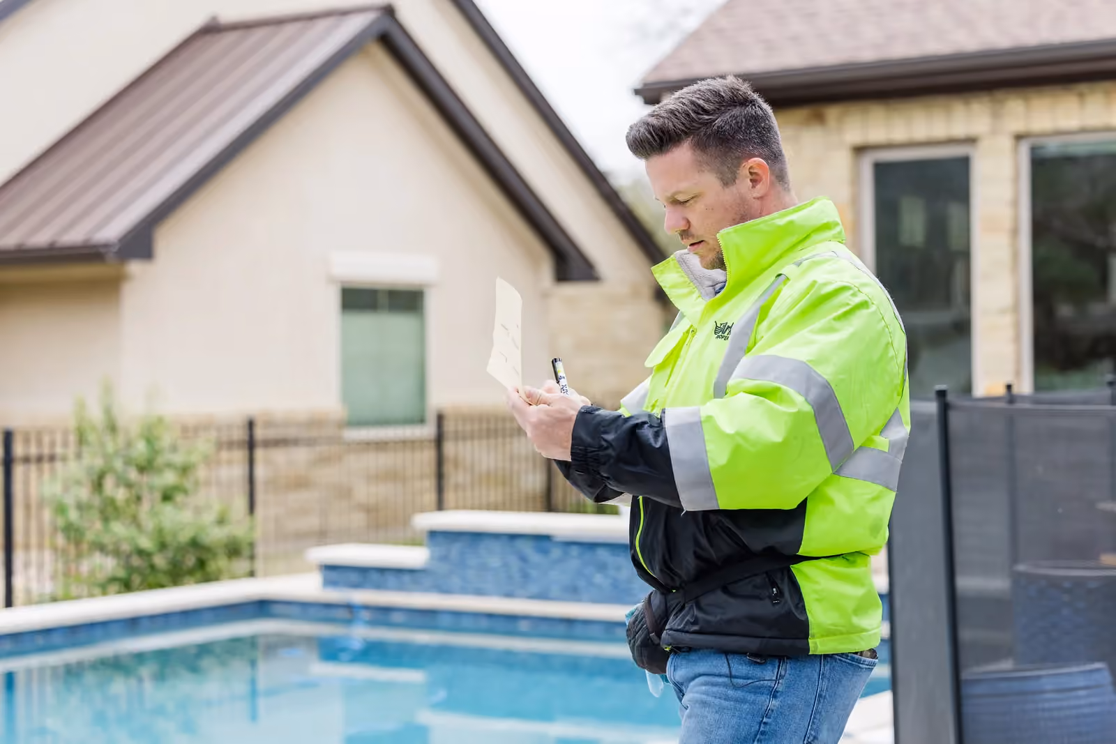 An Ark Roofer inspector recording field notes outside a Central Texas home