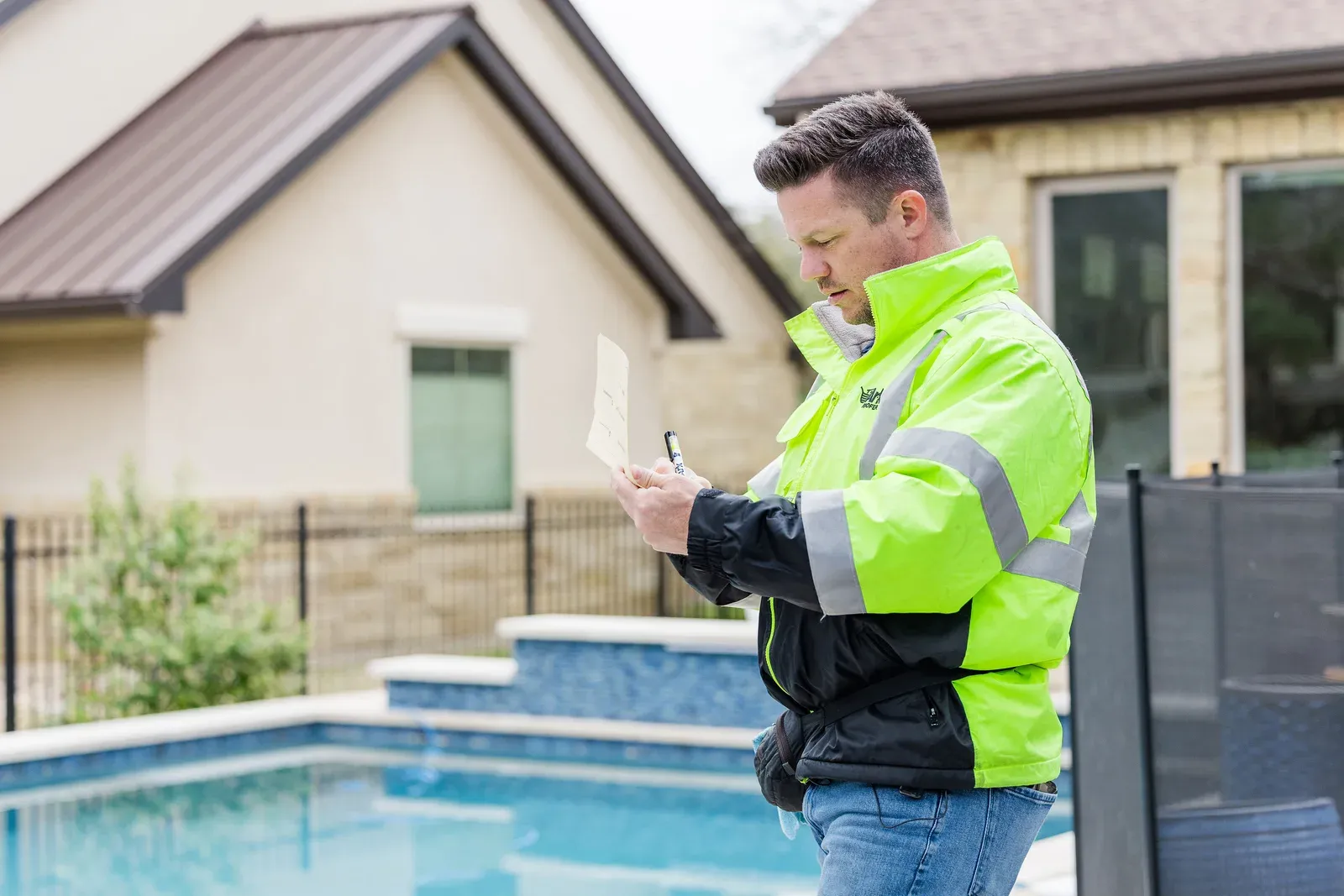 An Ark Roofer inspector recording field notes outside a Central Texas home