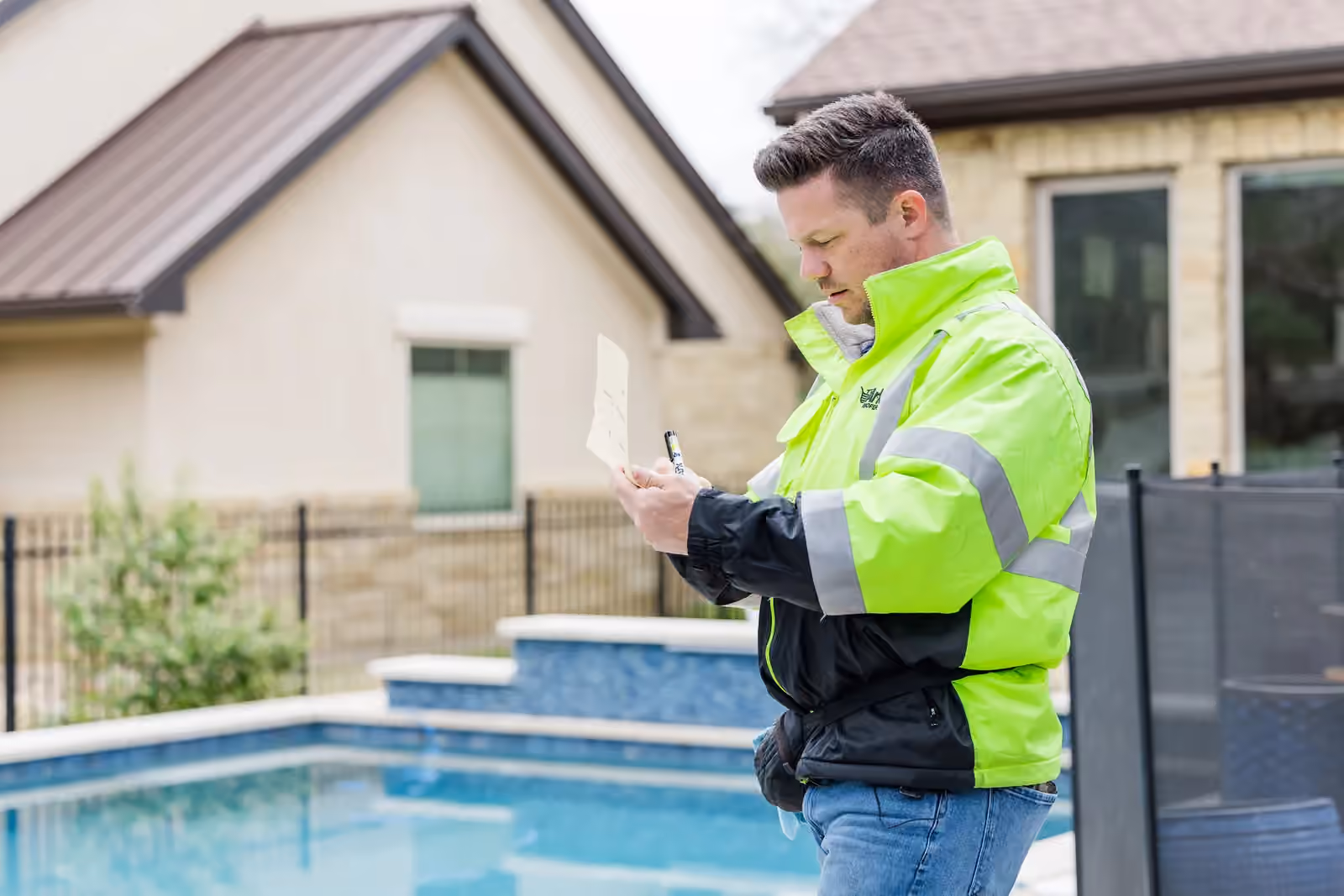 An Ark Roofer inspector recording field notes outside a Central Texas home